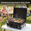 Portable Royal Gourmet grill with food being cooked, surrounded by people at a picnic table in a park.