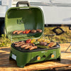 An outdoor green portable Royal Gourmet gas grill with its lid open, cooking sausages, burgers, peppers, and asparagus on a wooden table. The grill features two control knobs and the 'Grillmaster' brand logo on the front.
