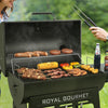 Person grilling food on a Royal Gourmet barbecue with vegetables and meats.