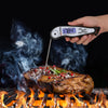 Royal Gourmet Digital thermometer reading 178.4øC on a steak with flames and smoke in the background