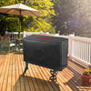 Black barbecue grill cover on a wooden deck with an umbrella and chairs in the background.