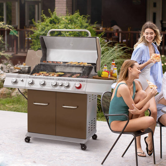 Two women enjoying a Royal Gourmet  barbecue outdoors with a large grill in the foreground.