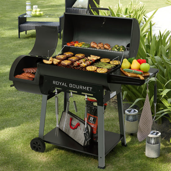 Black Royal Gourmet grill with food and vegetables on a grassy outdoor setting