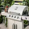 Stainless steel Royal Gourmet grill with seasoning bottles and utensils on a patio