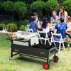 Creole Feast People enjoying a meal outdoors with a large portable grill in the foreground.