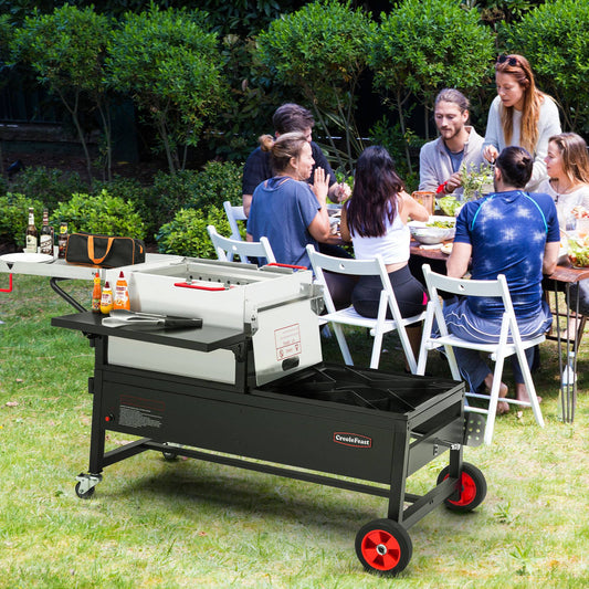 Creole Feast People enjoying a meal outdoors with a large portable grill in the foreground.