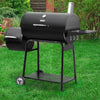 Black Royal Gourmet  barbecue grill on a grassy lawn with a garden background