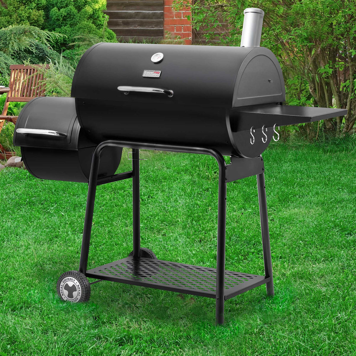 Black Royal Gourmet  barbecue grill on a grassy lawn with a garden background