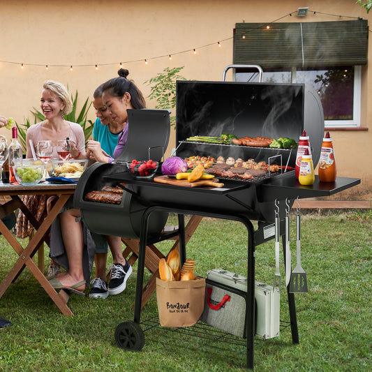 Two women grilling outdoors with a table of food and drinks.