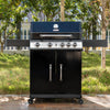 Black Royal Gourmet barbecue grill with a blue top on a wooden deck with trees in the background