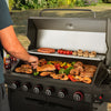 Person grilling various food items on a large Royal Gourmet barbecue grill outdoors.