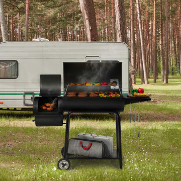 Royal Gourmet Barbecue grill with food being cooked in front of a trailer in a forest setting