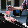 Person seasoning a steak on a Royal Gourmet  grill with a brush and spoon