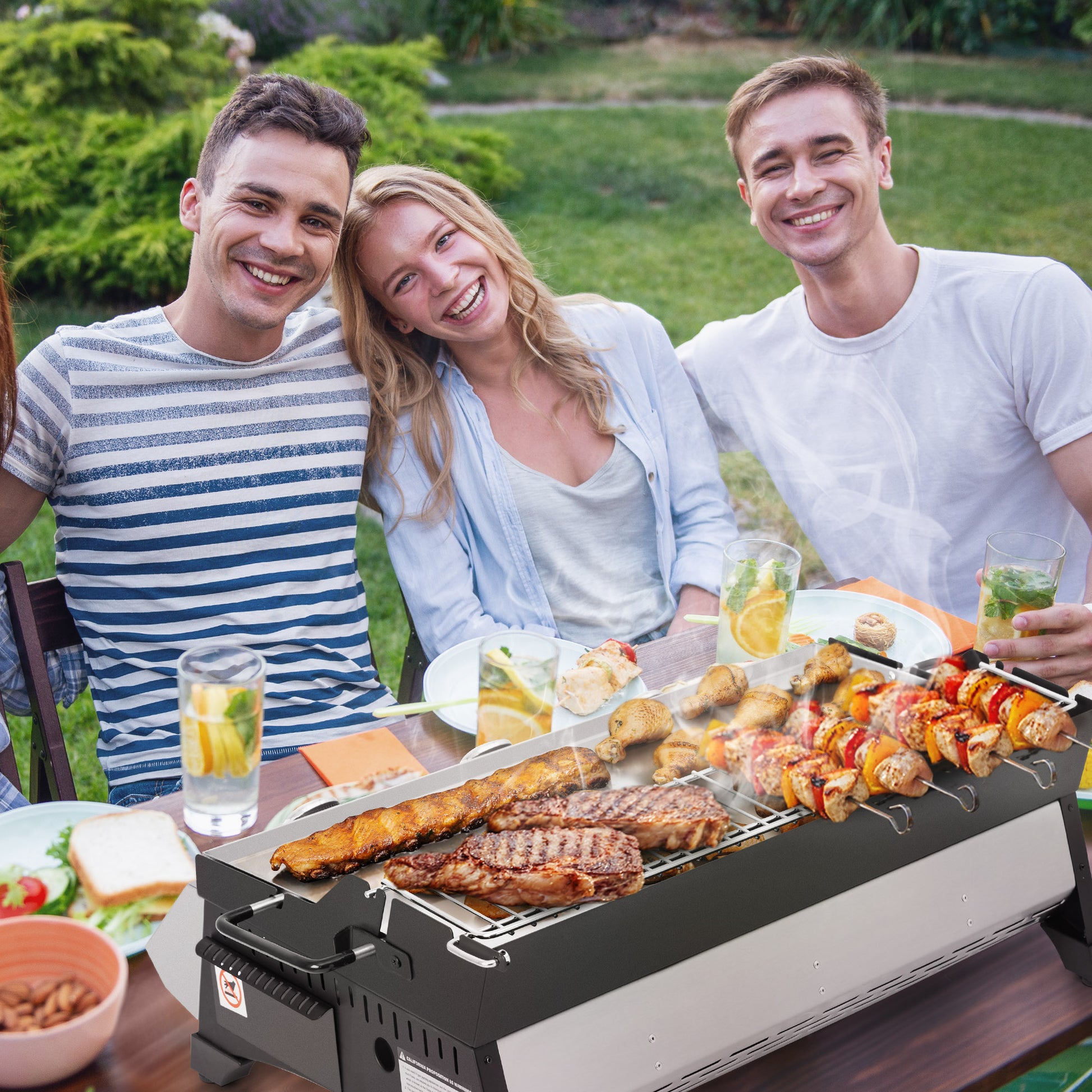 Three friends enjoying a barbecue outdoors with food and drinks on a Royal Gourmet  table.
