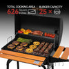A black outdoor Royal Gourmet gas grill with an open lid and extended wooden side tables, shown cooking burgers, steak skewers, asparagus, peppers, and tomatoes. White and red text at the top highlights cooking area and burger capacity, with a black-to-gray gradient background.