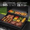 Open black Royal Gourmet outdoor grill with multiple foods cooking on the grates and a secondary rack above, set in a grassy outdoor area. Large text at the top reads 'TOTAL COOKING AREA 585 Square Inches' and 'BURGER CAPACITY 26 x'.