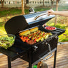 Person grilling vegetables on a Royal Gourmet portable grill outdoors