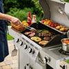 Person grilling vegetables and meats on a large outdoor Royal Gourmet  grill with condiments nearby.