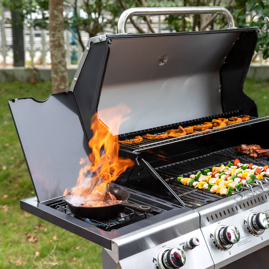 Royal Gourmet Outdoor grill with food being cooked on a grassy area