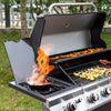 Royal Gourmet Outdoor grill with food being cooked on a grassy area