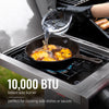 Person cooking outdoors with a portable Royal Gourmet  stove and frying pan, pouring liquid into food.