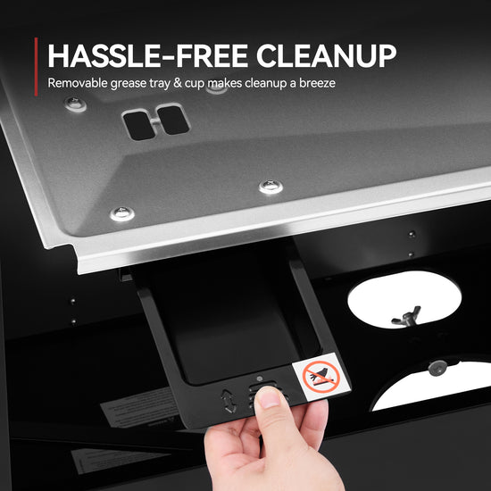 A close-up of a hand pulling open a black drawer in a stainless steel appliance, with text reading 'HASSLE-FREE CLEANUP' and a small no-smoking sticker on the drawer front.