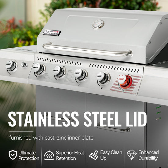 Stainless steel Royal Gourmet  grill with a focus on the lid and control knobs, set against a blurred outdoor background.