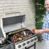 Man grilling outdoors with a Royal Gourmet barbecue and vegetables