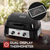 Black outdoor Royal Gourmet gas grill with a dual-display thermometer feature highlighted by an inset circle showing the thermometer dial, set on a wooden table with a blurred garden background.