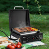 Portable Royal Gourmet grill with food on a grassy outdoor setting