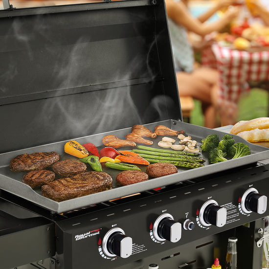 Royal Gourmet Grill with food cooking on a patio with people and a picnic table in the background