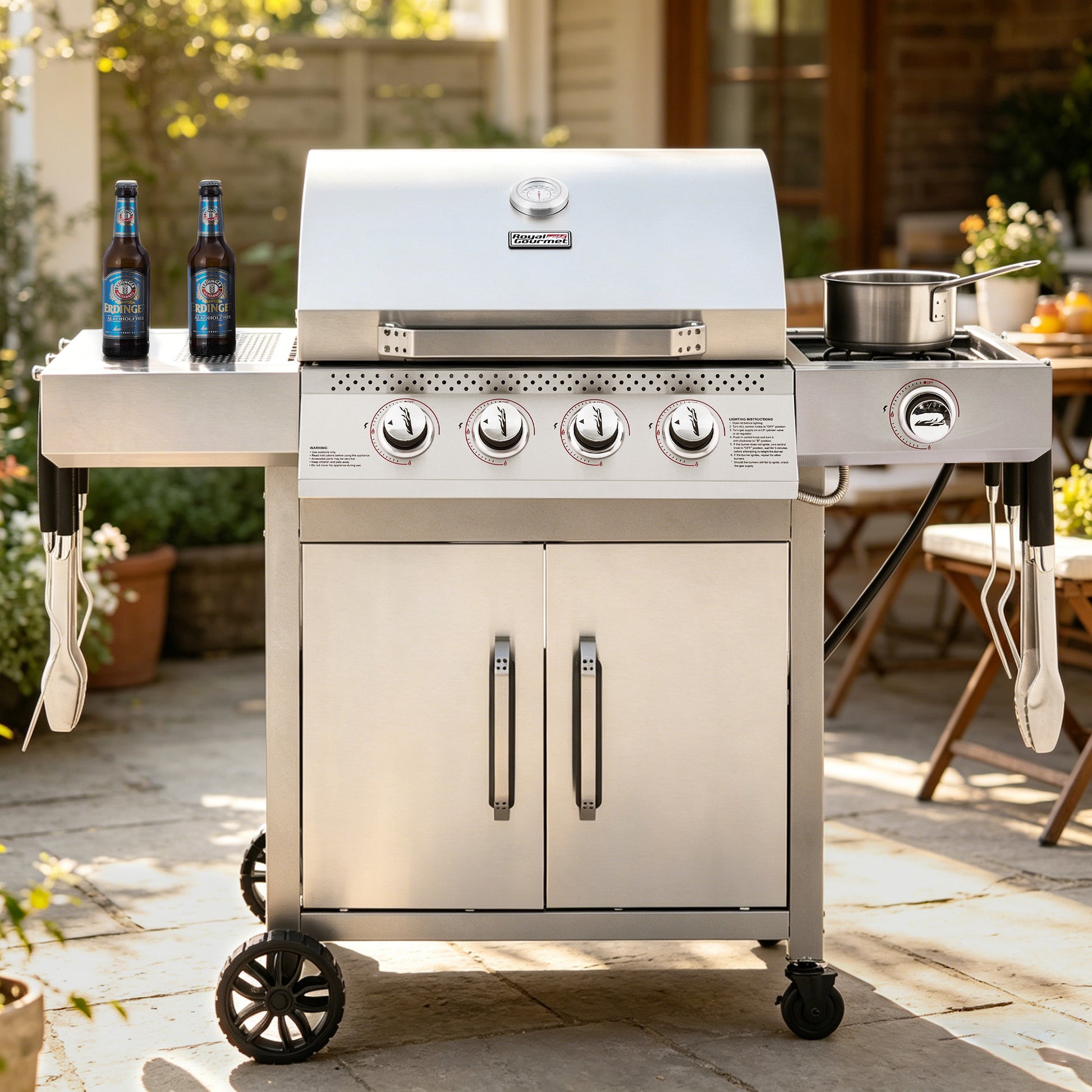 Stainless steel Royal Gourmet grill on wheels with beer bottles on top in an outdoor setting