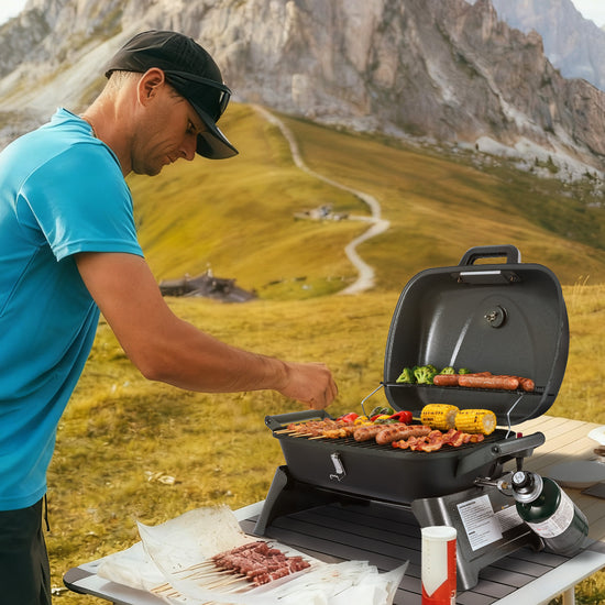 Man Royal Gourmet grilling outdoors with a scenic mountain background
