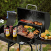 Royal Gourmet Portable grill with food and condiments on a table outdoors
