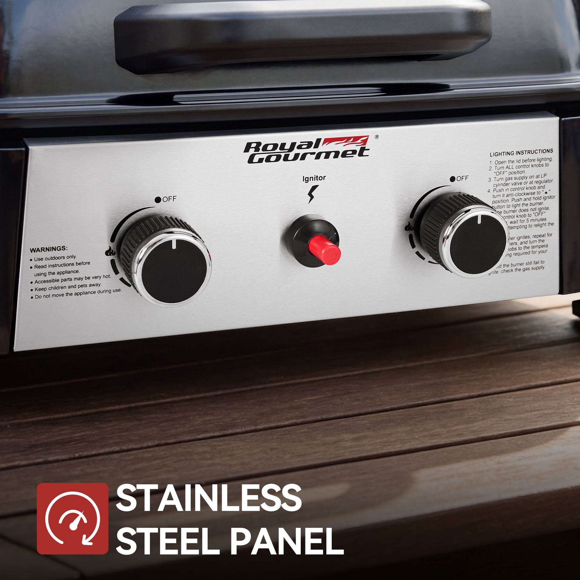 Close-up of a Royal Gourmet grill control panel with two black knobs, a red switch, and a stainless steel faceplate, shown on a dark wood surface with a text overlay reading 'STAINLESS STEEL PANEL'.