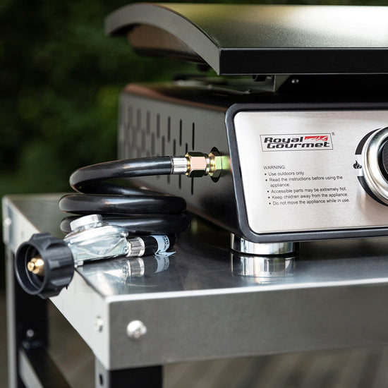Royal Gourmet Portable gas stove with hose and connectors on a reflective surface, brand 'Royal Gourmet' visible.