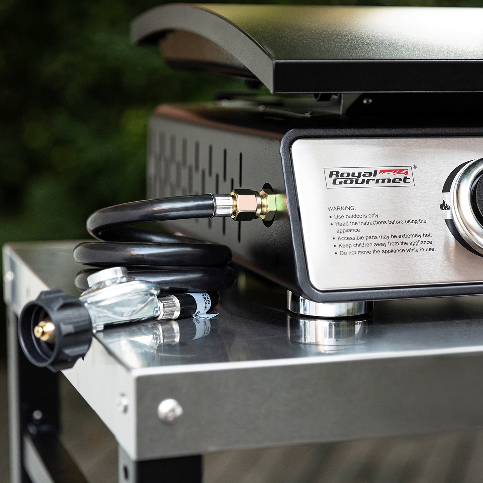 Royal Gourmet Portable gas stove with hose and connectors on a reflective surface, brand 'Royal Gourmet' visible.