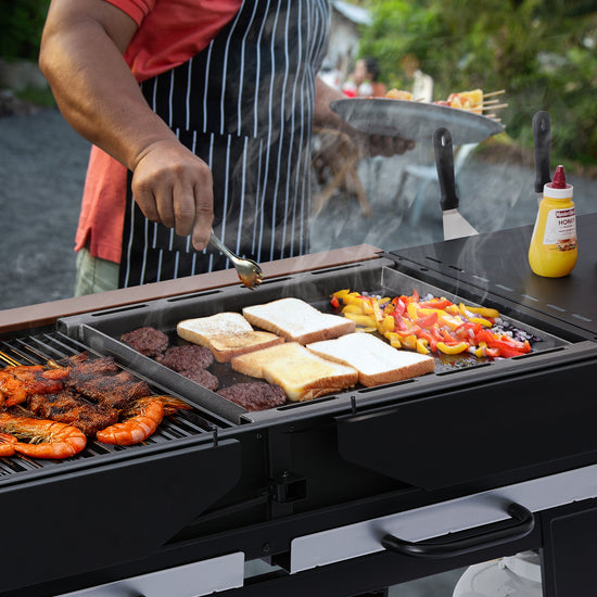 Person grilling food on a portable Royal Gourmet  grill with a mustard bottle in the background