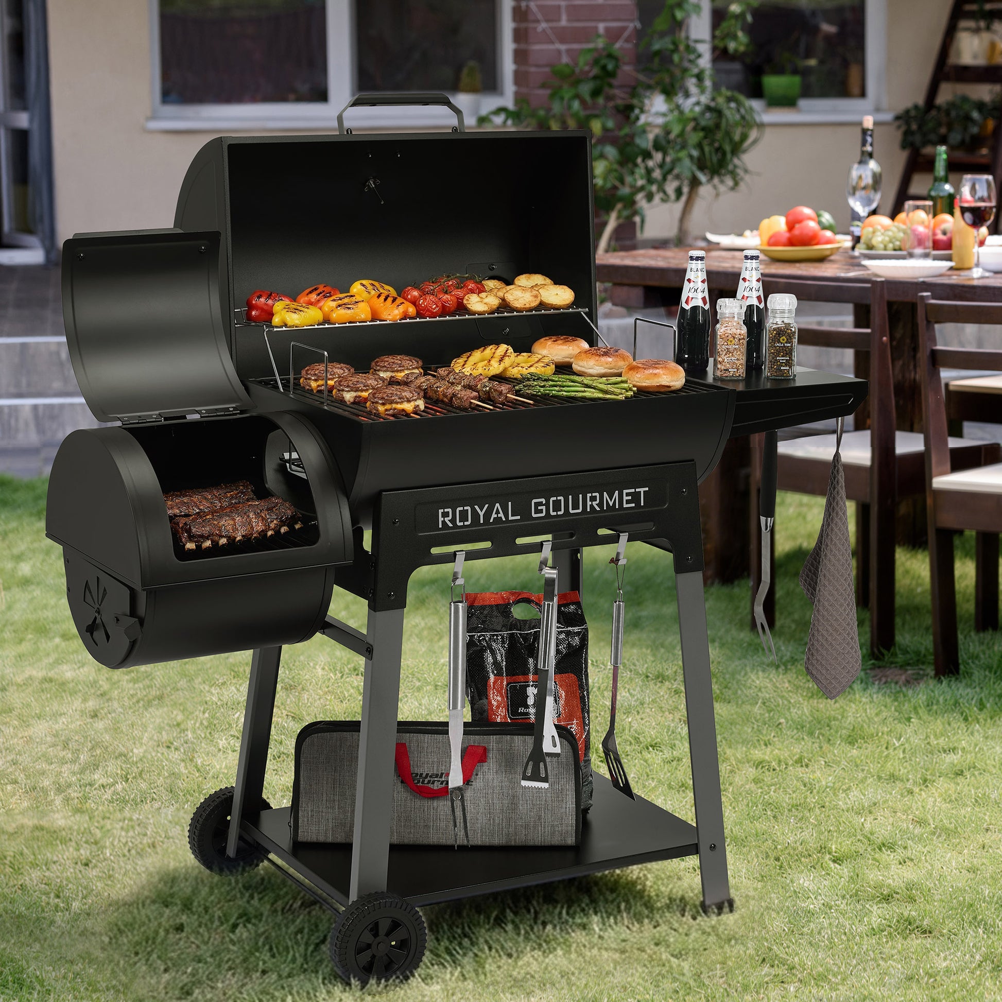 Black Royal Gourmet grill with food on a grassy outdoor area