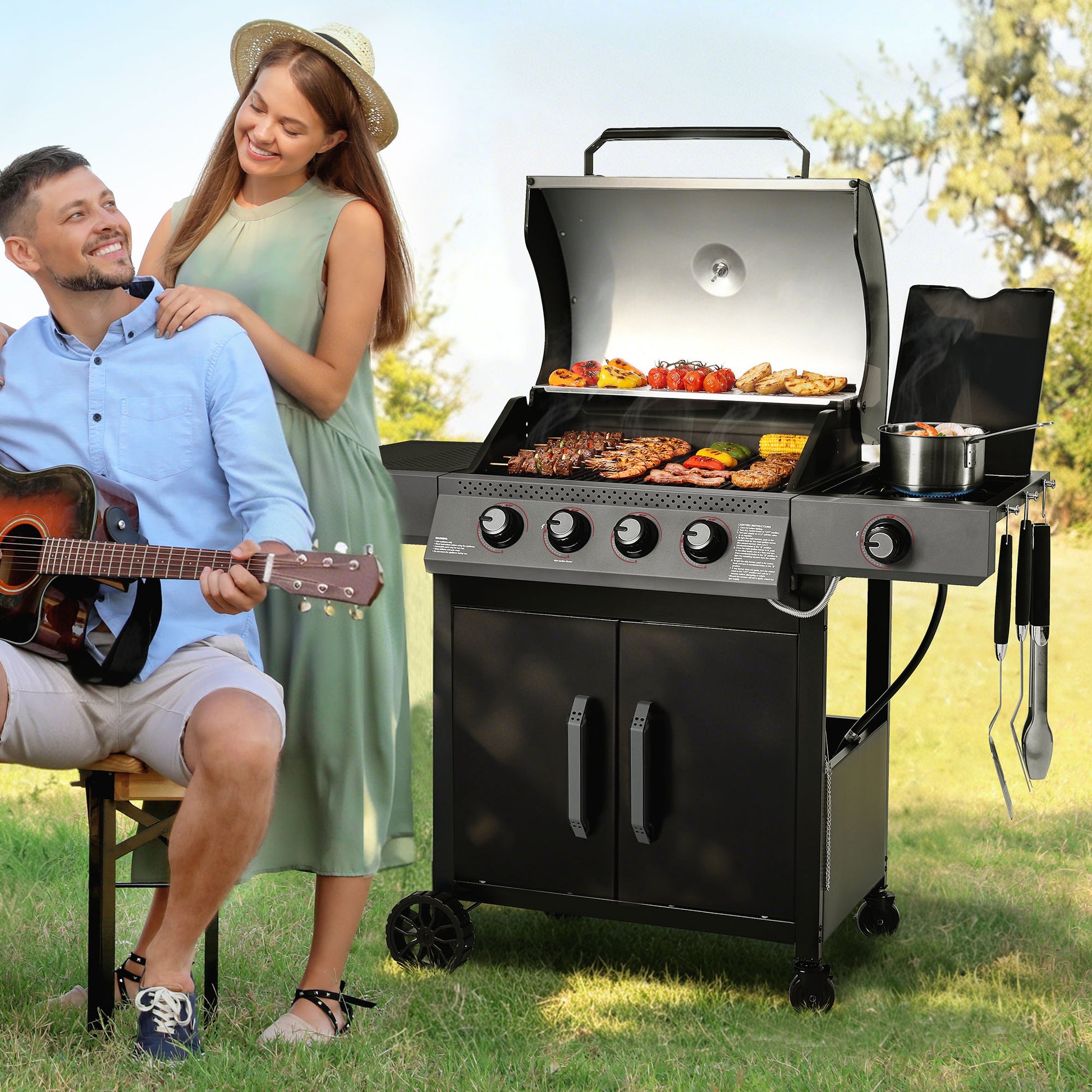 Man playing guitar and woman sitting next to a Royal Gourmet  barbecue grill with food on it in a park setting.