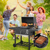 People enjoying a barbecue outdoors with a Royal Gourmet portable grill and food.