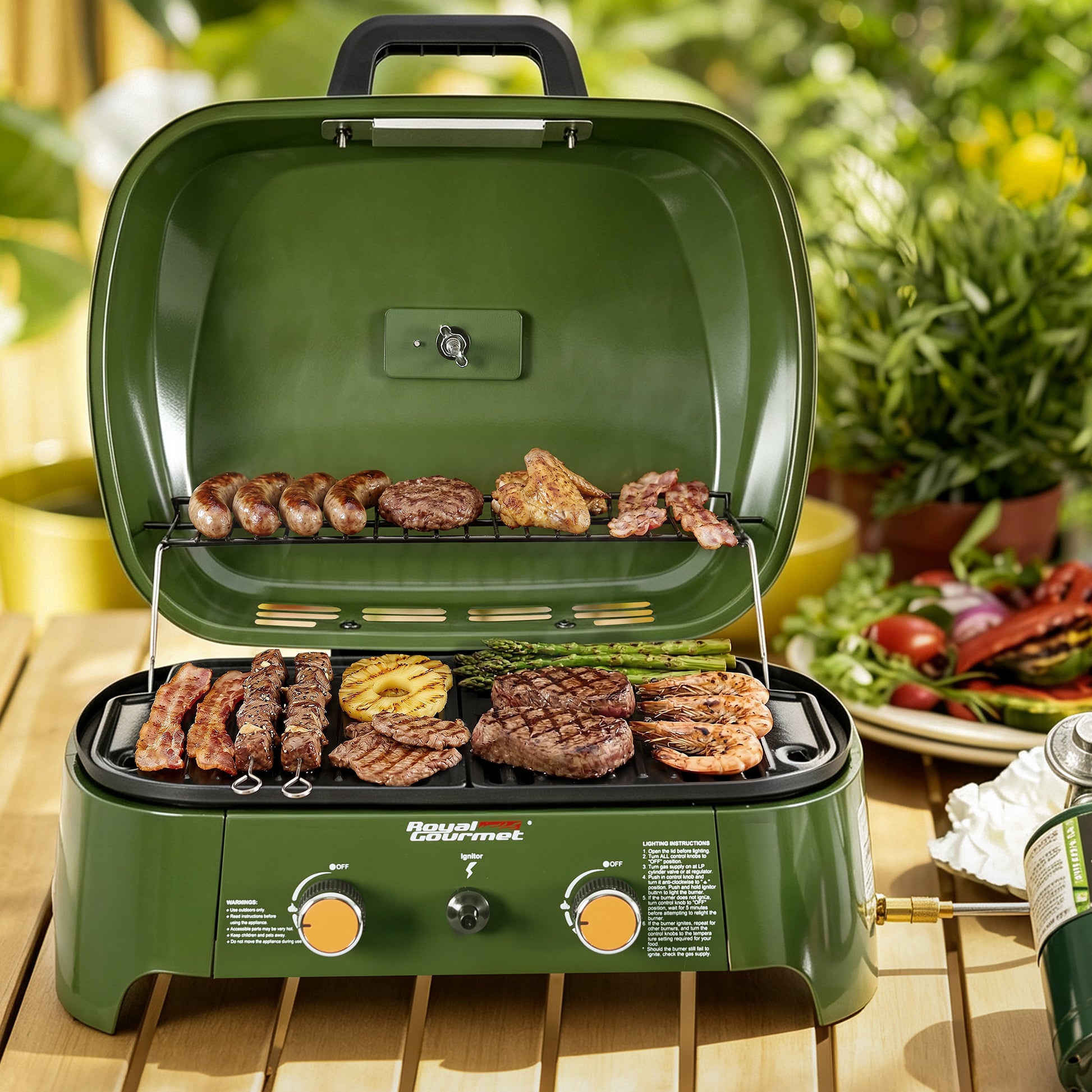 An olive green portable Royal Gourmet gas grill with food cooking inside, set on a wooden table with a blurred garden and outdoor dining background.