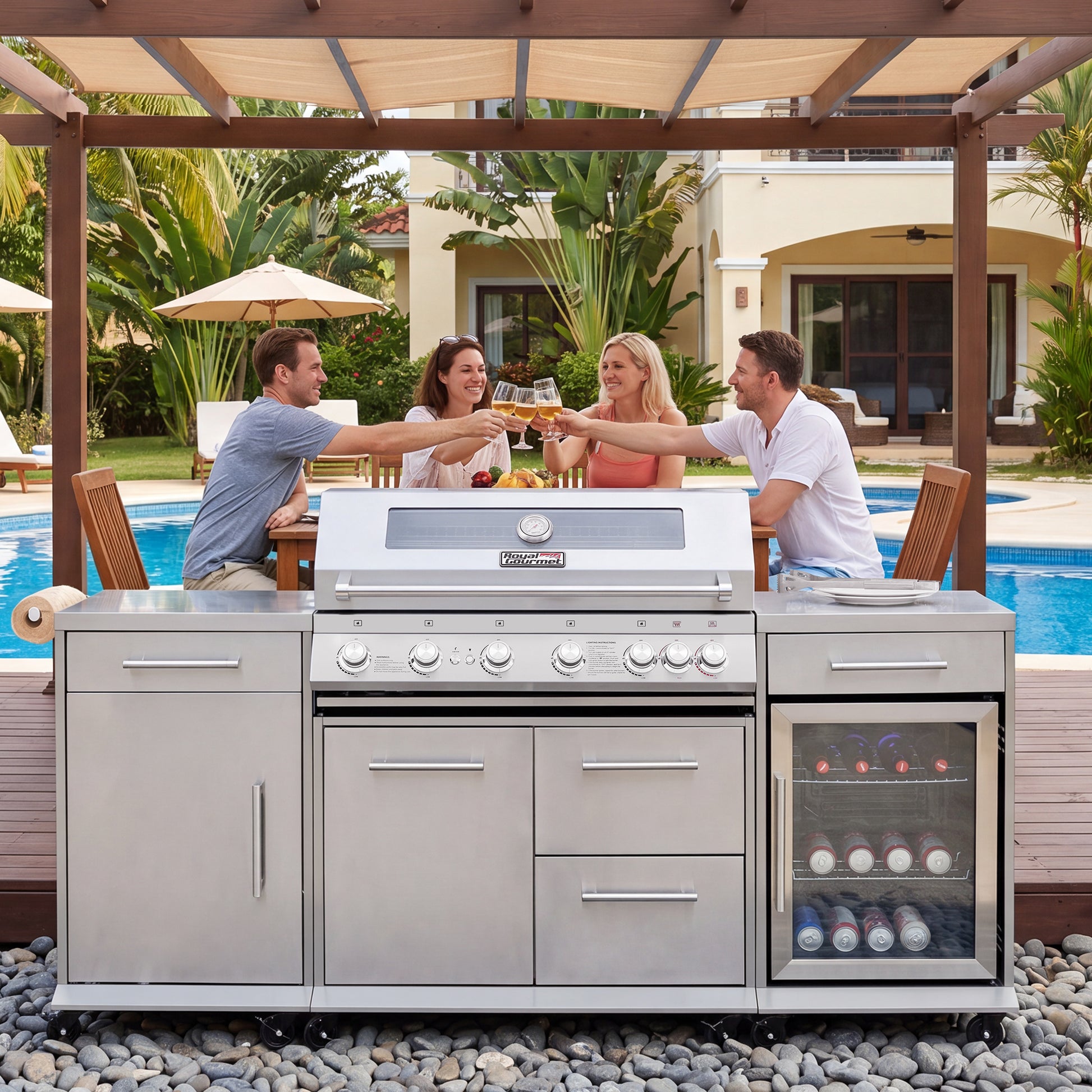 A large stainless steel Royal Gourmet outdoor kitchen island with a built-in gas grill, lower cabinets, drawers, and a glass-front wine cooler, shown in a backyard patio setting with three people toasting above it.