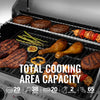 Grill with various foods cooking on it, including burgers, sausages, and chicken legs, with text indicating total cooking area capacity.