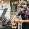 Man grilling food on a Royal Gourmet  barbecue grill outdoors with flags in the background
