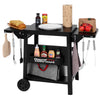 A black Royal Gourmet rolling kitchen cart with a top shelf, lower storage bin, and hanging utensils, shown on a white background with food props and condiments placed on and inside it.