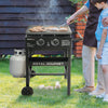 Person grilling on a Royal Gourmet portable grill with a child watching outdoors.