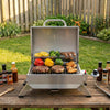 Portable Royal Gourmet   grill with food on a wooden table outdoors
