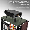 Portable pizza oven on a sturdy tabletop with storage space and condiments.