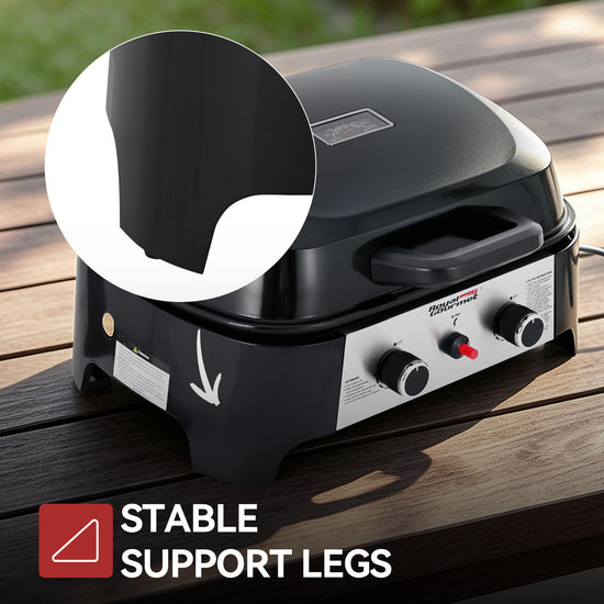 Black portable Royal Gourmet gas grill with support legs on a wooden table, featuring a circular inset showing the underside of the lid and text reading 'STABLE SUPPORT LEGS'.